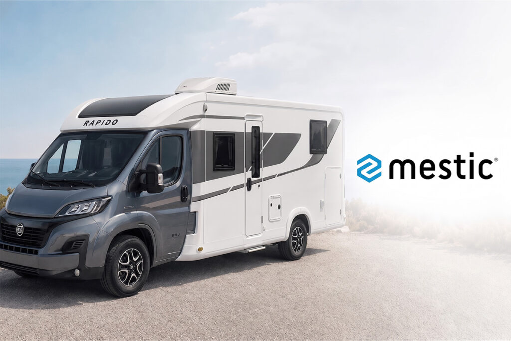 Camping-car Rapido garé en bord de mer avec le logo Mestic sur fond blanc.