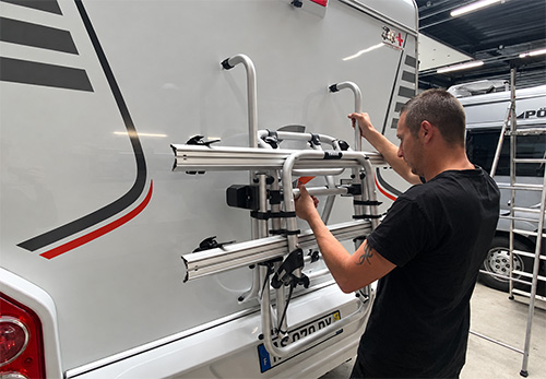 Technicien en train de poser un porte-vélos à l'arrière d'un camping-car