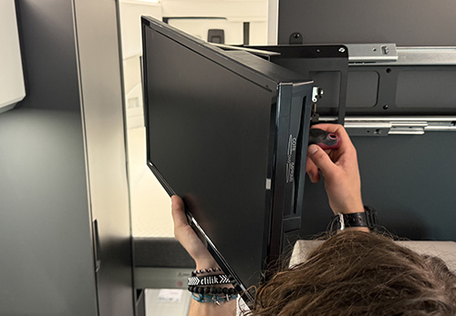 Technicien en train de poser une smart TV dans un fourgon aménagé